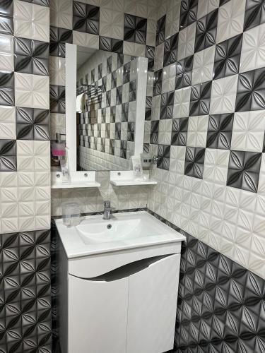 a bathroom with a white sink and a mirror at Hotel Manjit Banquet in Fālākāta