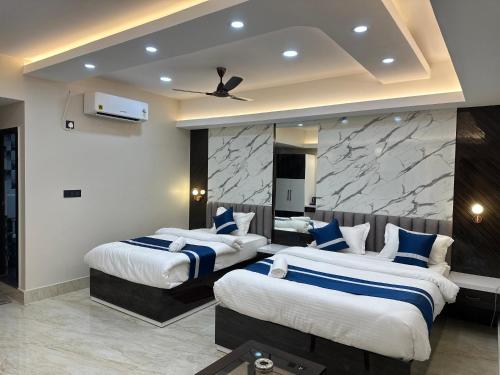two beds in a hotel room with a ceiling fan at Hotel Manjit Banquet in Fālākāta