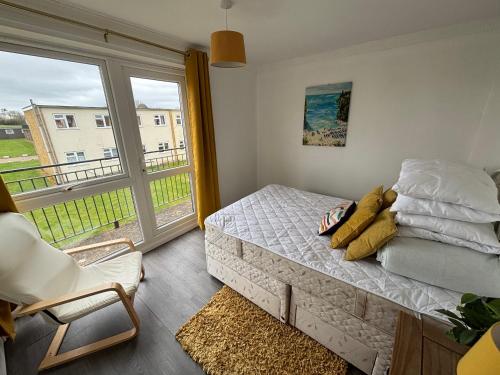 a bedroom with a bed and a large window at 124, Three bed two storey chalet on Bermuda holiday park, Hemsby - Sleeps 7, bed linen and towels included with onsite entertainment and further entertainment close by - includes balcony in Great Yarmouth