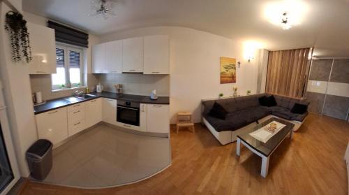 a kitchen and a living room with a couch and a table at Apartman Omazić in Livno