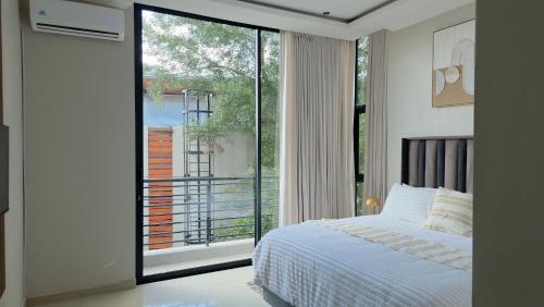 a bedroom with a bed and a large window at VnA Executive Suites in Pretoria