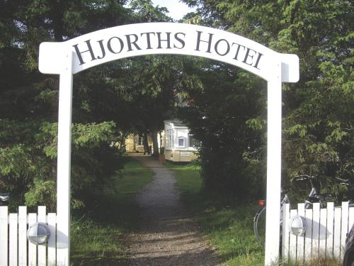 a sign for a huthtis hotel on a road at Hjorths Badehotel in Kandestederne