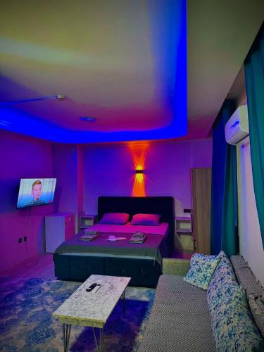 a bedroom with a bed and a couch and a purple ceiling at Damla Apart Otel in Buca