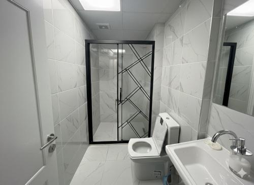 a bathroom with a shower and a toilet and a sink at Damla Apart Otel in Buca