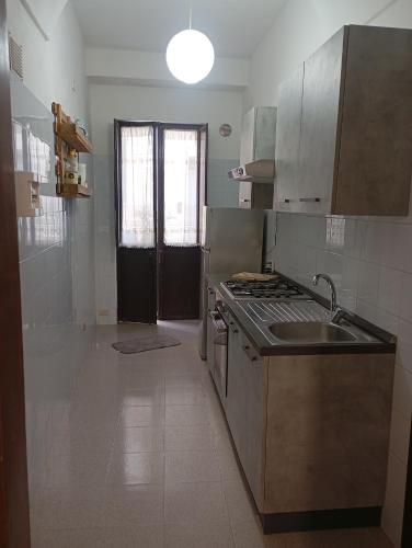 a kitchen with a sink and a stove top oven at Da Adriana NETUM in Noto