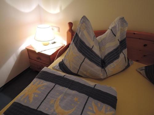 a bedroom with a bed with a pillow and a lamp at Haus Pfeiffenberger in Eben im Pongau