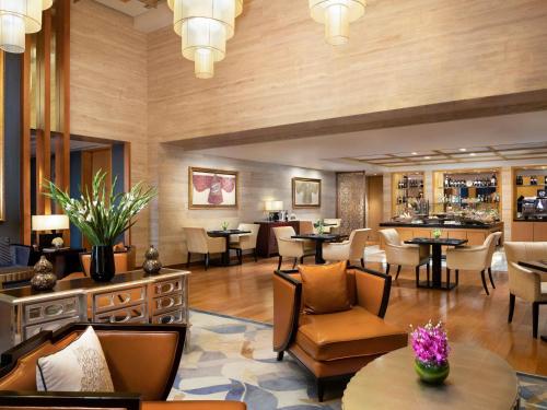 a lobby of a hotel with tables and chairs at Fairmont Beijing in Beijing