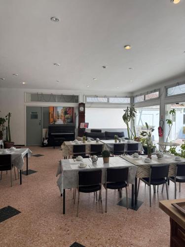 a large room with tables and chairs and a piano at HOTEL LE FLOREAL in Le Soler