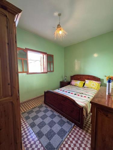 a bedroom with a bed in a green room at Love Wave House in Agadir