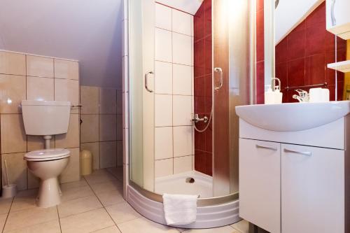 a bathroom with a shower and a toilet and a sink at Plitvice Palace Rooms - Adults Only in Grabovac