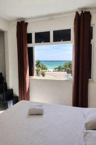 a bedroom with a bed and a view of a beach at Hotel Netuno Beach in Fortaleza