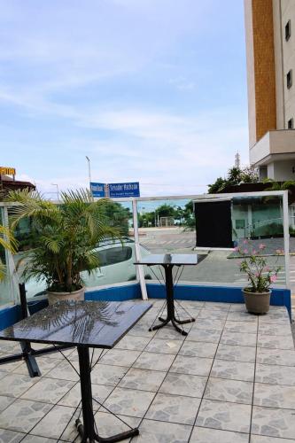 a patio with a table and a sign on a building at Hotel Netuno Beach in Fortaleza