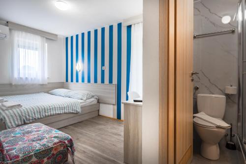 a small bedroom with a bed and a toilet at Maestral Residence in Portorož