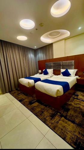 a bedroom with two beds with blue pillows at حياه الأصيل للشقق الفندقية in Jeddah