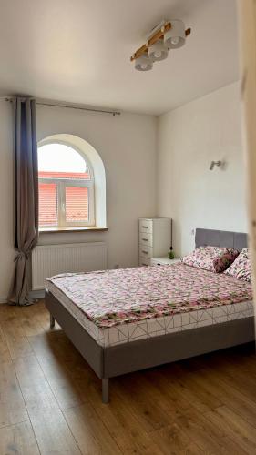a bedroom with a bed in a room with a window at Апартаменти над каньйоном in Kamianets-Podilskyi