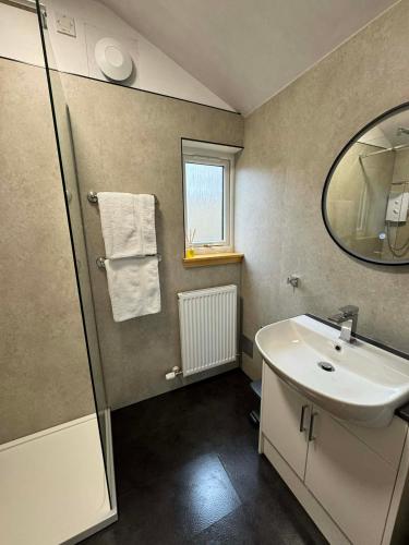 a bathroom with a sink and a mirror at 1 Manse Lane in Portree