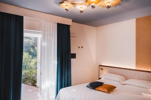 a bedroom with a bed and a large window at Tuscany Hotel Alle Dune in Marina di Castagneto Carducci