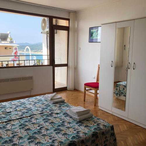 a bedroom with a bed and a large window at Villa Rocky in Sozopol