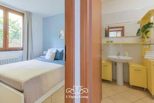 a bedroom with a bed and a sink at Méa Mare Apartment - L'Opera Group in Riomaggiore