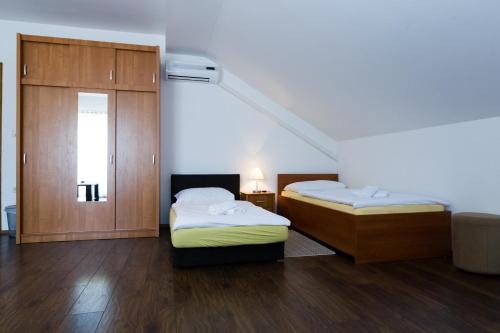 a room with two beds and a closet at Plitvice Palace Rooms - Adults Only in Grabovac