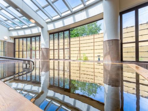 a pool in a building with a glass ceiling at LiVEMAX Resort Upopoi Shiraoi Onsen in Shiraoi
