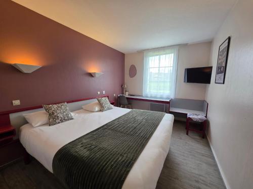 a hotel room with a large bed and a window at Hotel Saint Odilon in Cluny