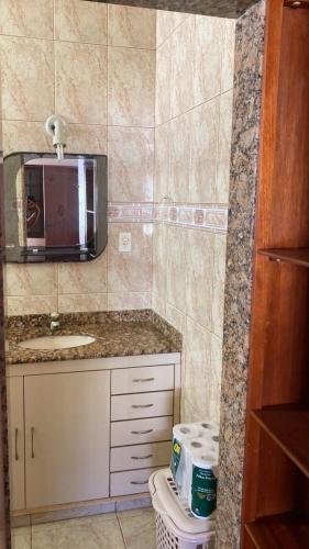 a small bathroom with a sink and a microwave at Refugio Paraiso in Arraial do Cabo
