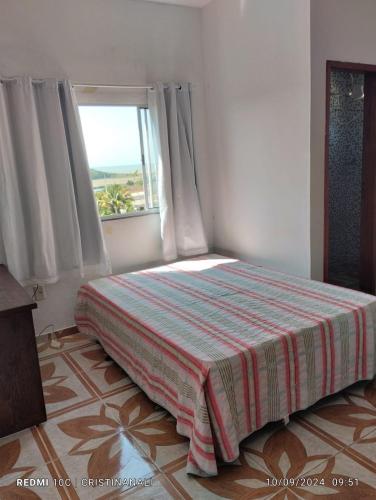 a bedroom with a bed with a window and a floor at Kitinet in Marataizes