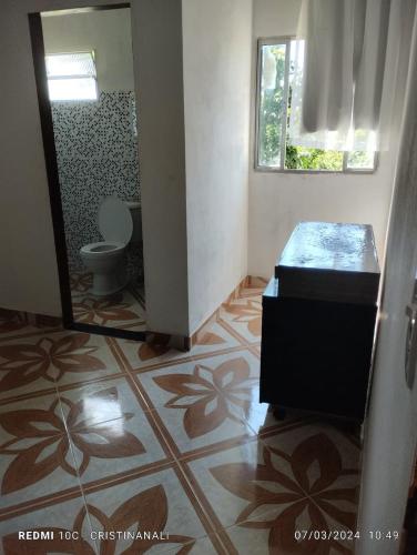 a bathroom with a toilet and a mirror at Kitinet in Marataizes