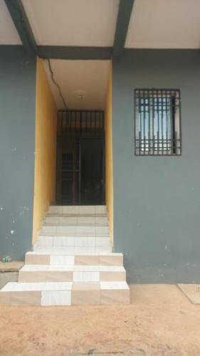 an empty room with white stairs and a window at NT Dreamhouse Cameroon in Zalom