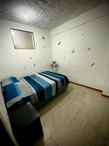 a bedroom with a bed and a wall with butterflies at Palmeras 2 in Manizales