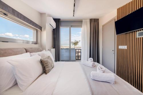 a bedroom with a large white bed with a large window at The HostMaster 910 Loft in Piraeus