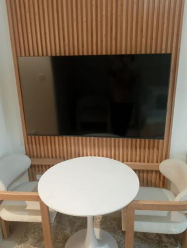 a living room with a white table and a television at Nasma - Modern Apartments with Balcony in Azizi Riviera in Dubai