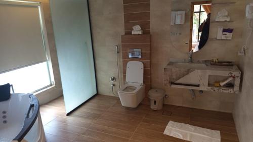 a bathroom with a toilet and a sink and a mirror at كوخ ساره سبيشل in Al-ʿUla