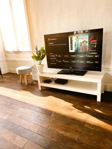 a large flat screen tv sitting on a white table at Le Repos Poitevin Studio Atypique in Vivonne