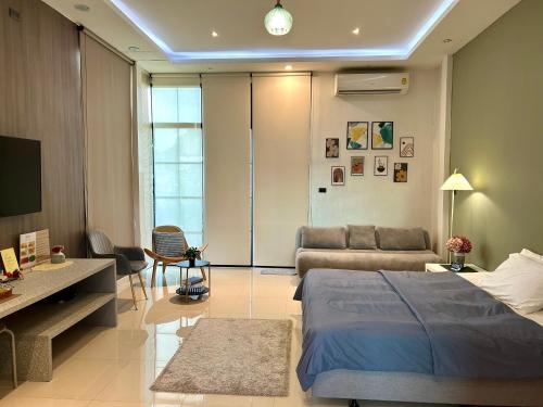 a bedroom with a bed and a living room at Ellie House Phuket Old Town in Ban Rangeng