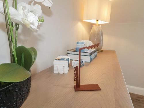a table with a lamp and a stack of books on it at Portnablagh Cottage in Dunfanaghy