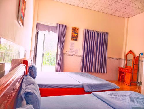 a bedroom with two beds and a window at Đức Phát Homestay in Tân Phú