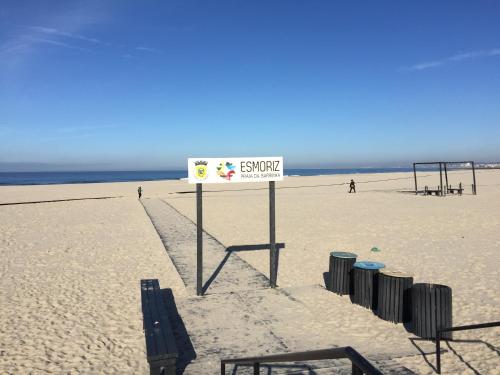 a sign on a beach with a volley ball net at Casa Lagoa Verde in Esmoriz