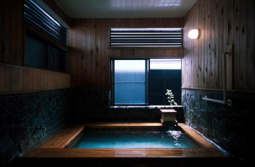 a jacuzzi tub in a room with a window at 一棟宿 倉持 in Kusatsu