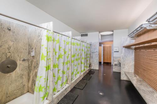 a bathroom with a shower with green and white tiles at HI Viana do Castelo - Pousada de Juventude in Viana do Castelo