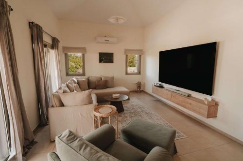 a living room with a large flat screen tv at Stylish villa with sea view in Peyia