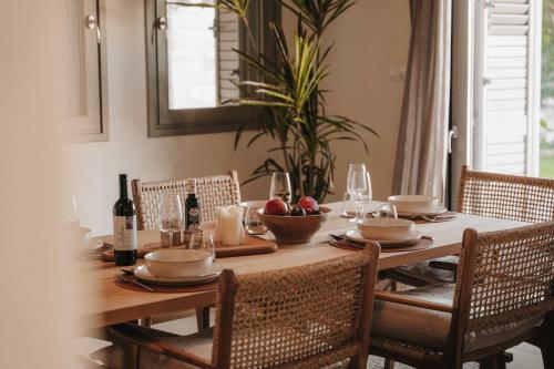 a dining room table with a bowl of fruit and wine bottles at Stylish villa with sea view in Peyia