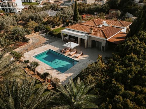 an aerial view of a house with a swimming pool at Stylish villa with sea view in Peyia