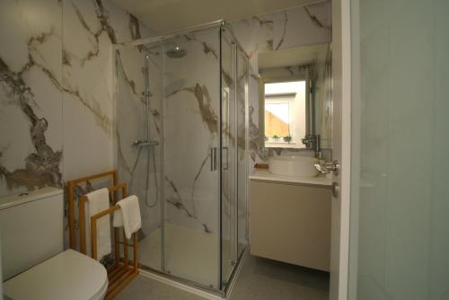 a bathroom with a shower and a toilet and a sink at Casa Ti Madalena in Arganil