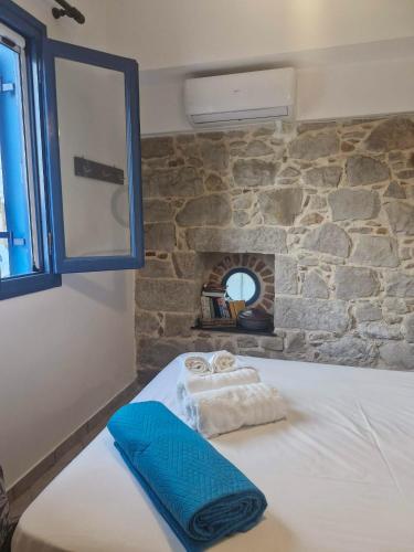 a bed in a room with a stone fireplace at Thalias apartments in Kómi