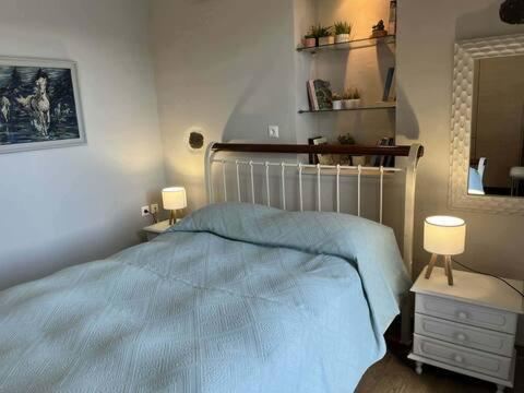 a bedroom with a blue bed and a mirror at Sunrise View in Kardámyla