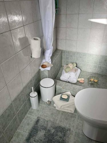 a bathroom with a sink and a toilet and towels at Sunrise View in Kardámyla