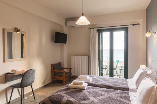 a bedroom with a bed and a table and a balcony at Gorgones, sea-front, great view in Kardamyli