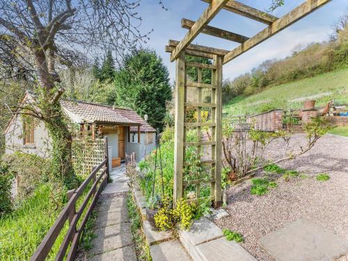 a garden with a pergola in front of a house at Hayloft - E3759 in Berrynarbor